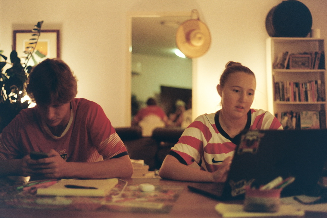 The KADI cofounders working at a table with a laptop, phone, and open notebook.